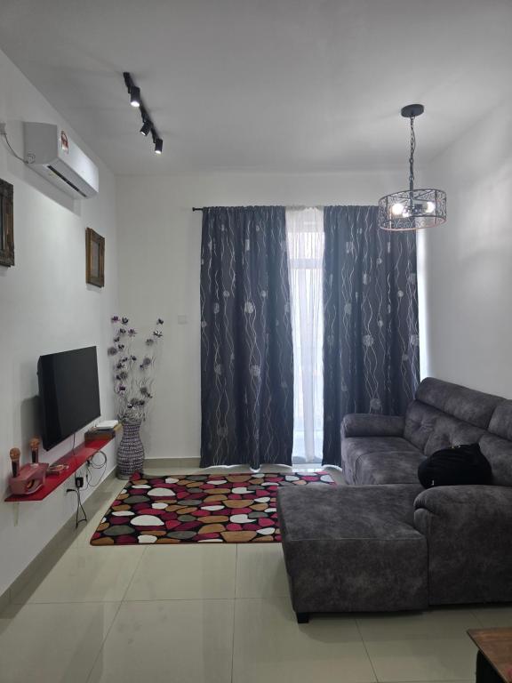 a living room with a couch and a television at Aliffheight in Johor Bahru