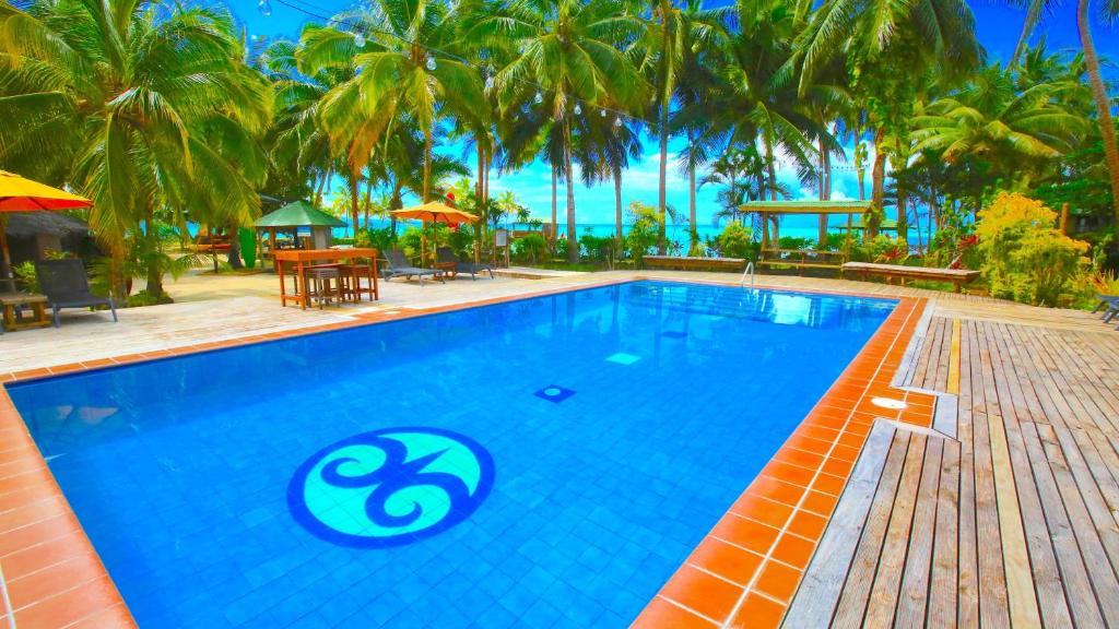 a swimming pool at a resort with palm trees at Le Vasa Resort in Fuailalo