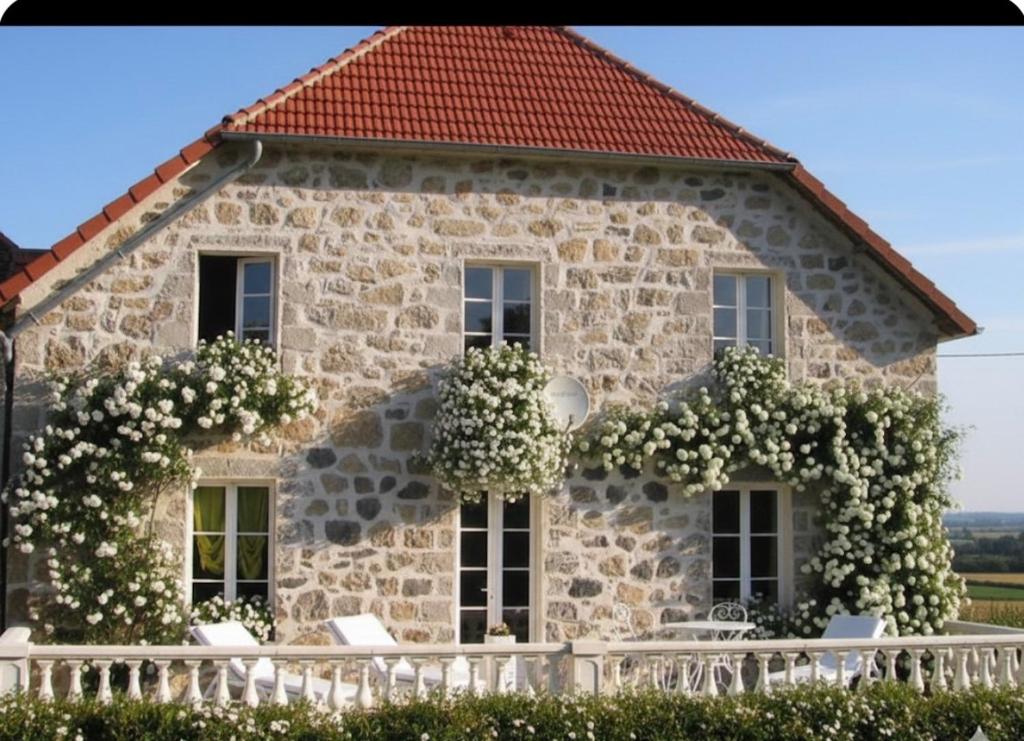 a stone house with white chairs in front of it at Loire-Gerbier-Mézenc in Sainte-Eulalie