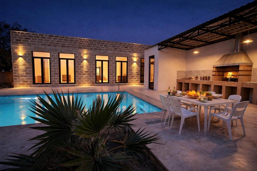 a house with a pool and a table and chairs at Villa Fratello in Baku