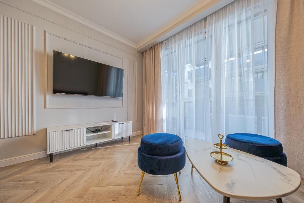 a living room with a television and two blue stools at Azure Mostek Oldtown in Gdańsk
