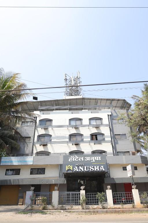 an apartment building with a sign in front of it at Anusha Hotel in Nashik