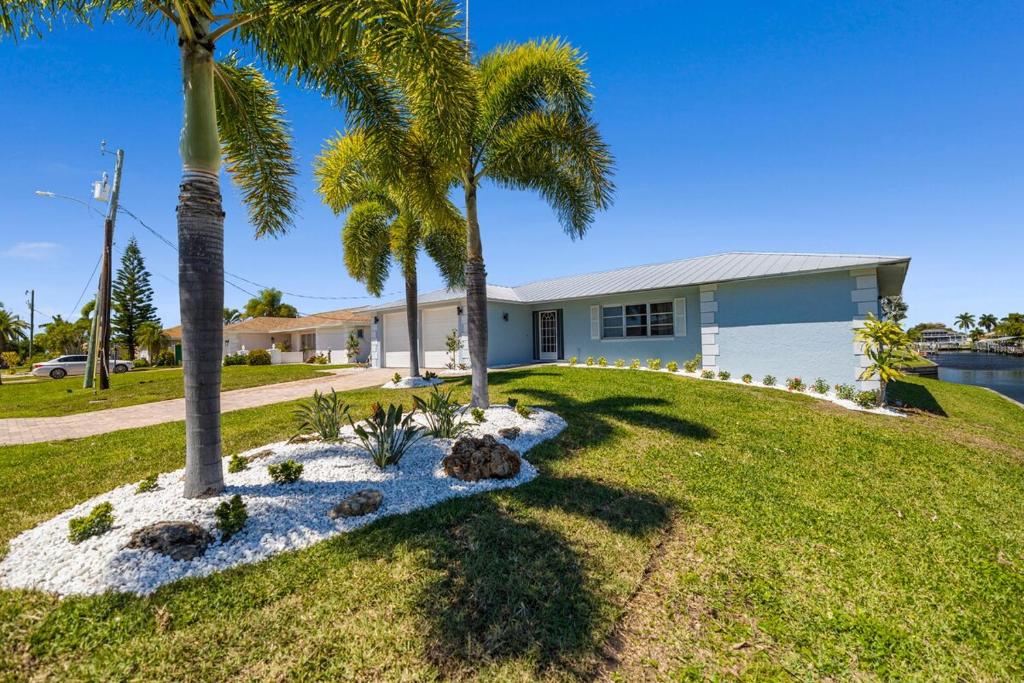 a house with palm trees in the yard at Waterfront Oasis in Cape Coral