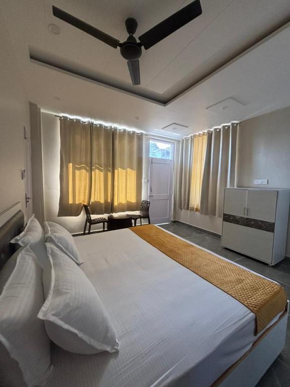 a bedroom with a large white bed with a ceiling at ZuZu Hostels Mcleodganj in Dharamshala