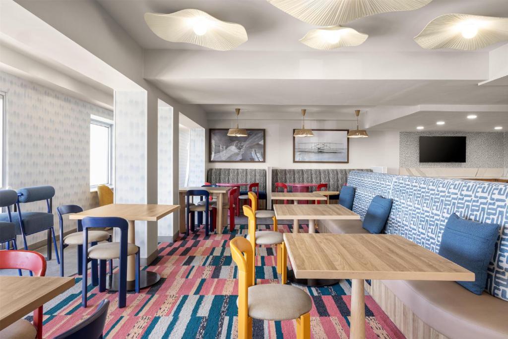 a dining room with wooden tables and chairs at Home2 Suites by Hilton Outer Banks Kill Devil Hills in Kill Devil Hills