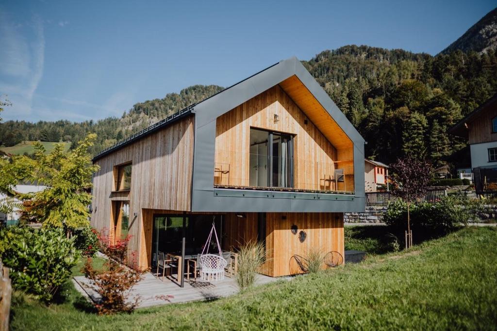 a wooden house with a balcony on a hill at Bergliebe Rabenstein in Scheffau am Tennengebirge