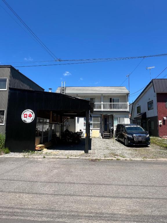 a black car parked in front of a house at 旭川ロキ in Asahikawa