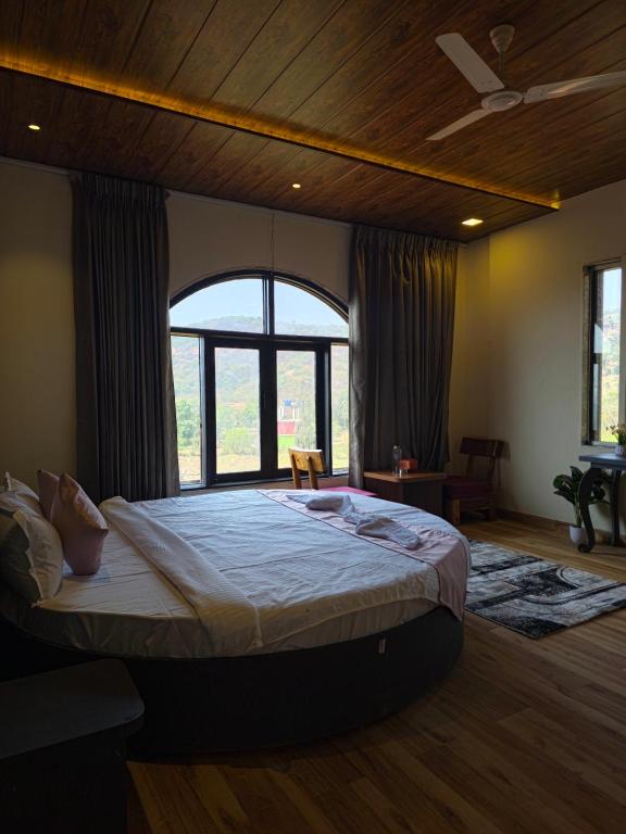 a bedroom with a large bed with a large window at Miransh Heavenly in Dapoli