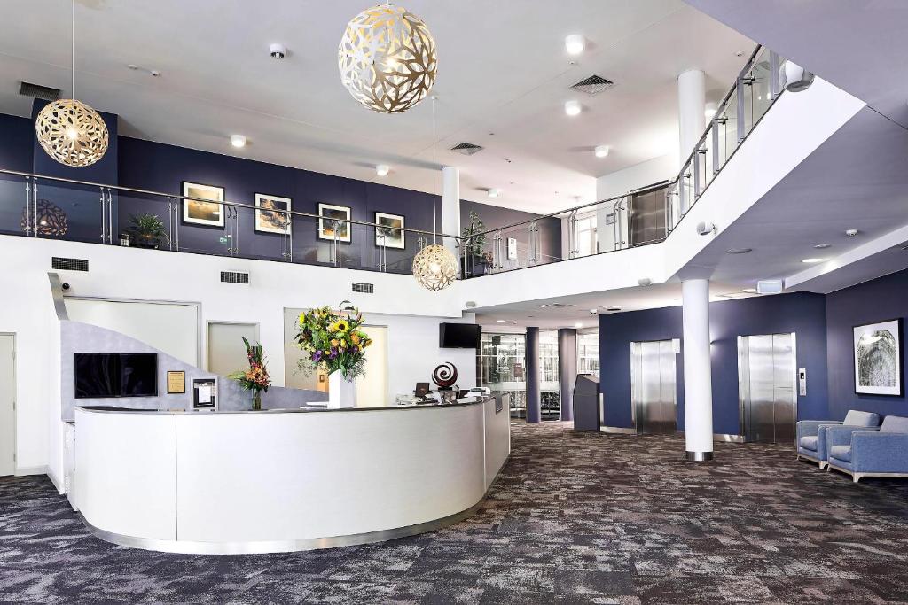 an office lobby with a reception counter and blue walls at Quality Hotel Dickson in Canberra
