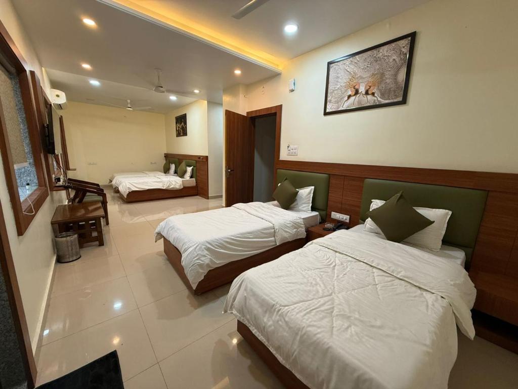 a hotel room with two beds in a room at Hotel Sunrise in Damoh