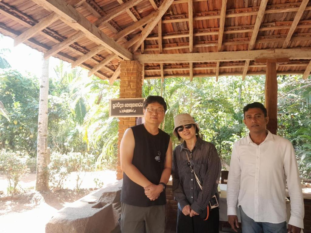 a group of three people standing under a roof at Swastha Retreat in Polgahawila