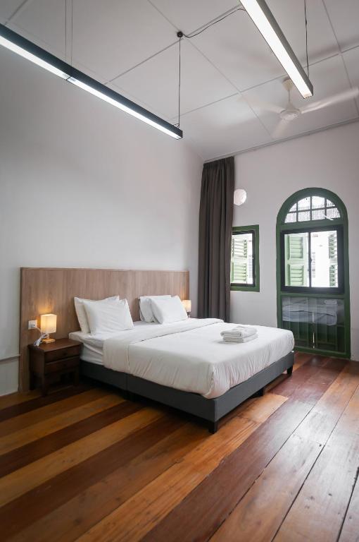 a bedroom with a large white bed and wooden floors at Aceh Suites by Aayu - 1 min walk to Armenian St in George Town