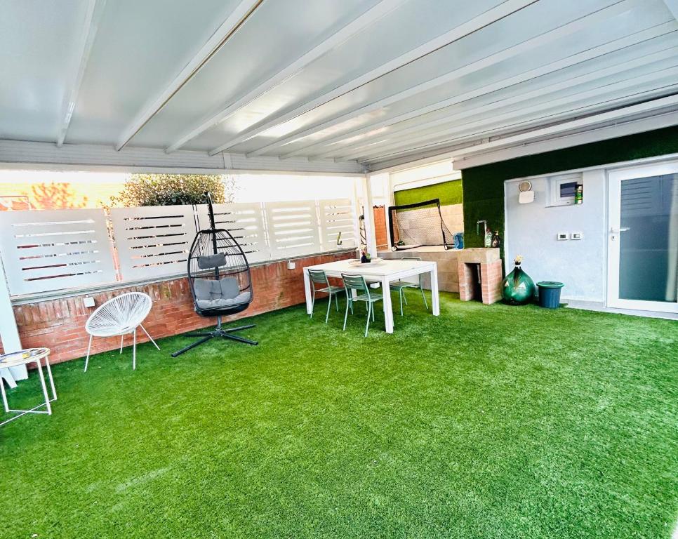 a patio with green grass and a table and chairs at Touch&Go - Stanza privata con servizi in Ciampino