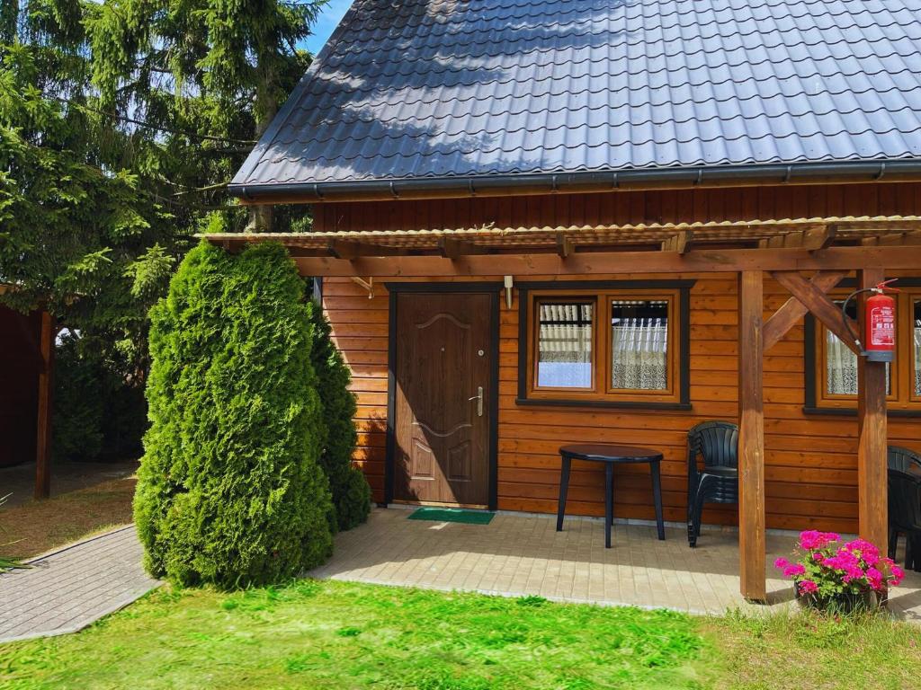 a small wooden house with a table in front of it at Domki Vesper Międzywodzie in Międzywodzie