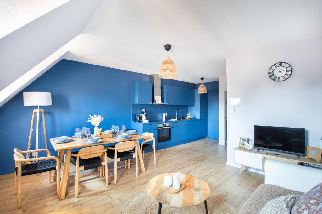 a dining room with blue walls and a table and chairs at Le P'tit Bretzel in Turckheim