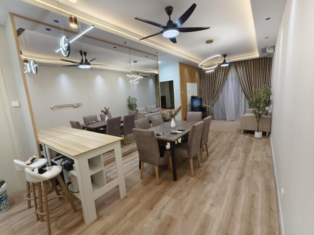 a dining room with a table and chairs and a ceiling fan at MyShelter Melaka in Kelebang Besar