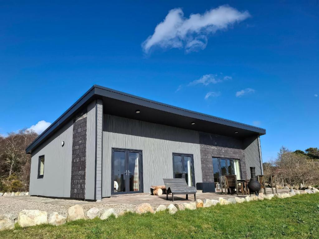 a small house with a black roof at Red Squirrel in Dornoch