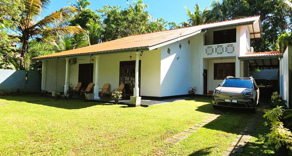 a car parked in front of a house at Villa Mango Serenity in Hikkaduwa