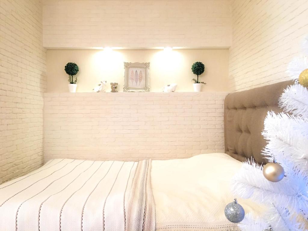 een bed in een kamer met een bakstenen muur bij Studio Luxe on Victory Street in the city center in Vinnytsya