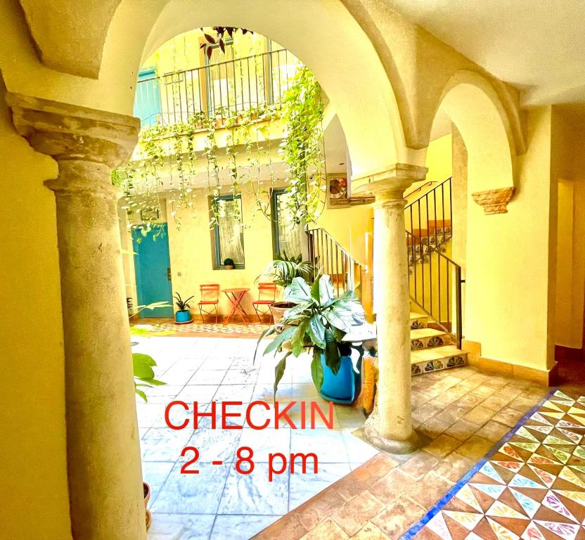 a building with an archway with a plant in a courtyard at Hotel Conde de Cárdenas in Córdoba