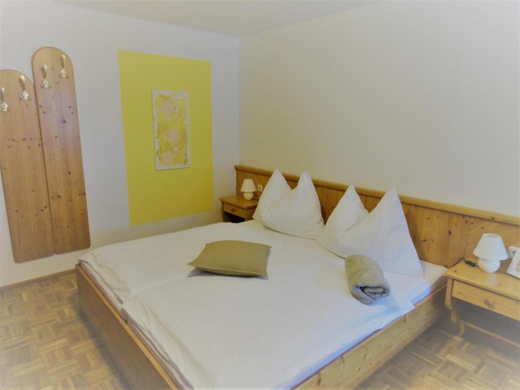 a bedroom with a bed with white sheets and pillows at Wohlfühlpension Kreischberg in Sankt Georgen ob Murau
