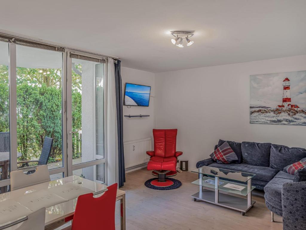 a living room with a couch and a red chair at Objekt-Nr 86 - Priwall - Wiekstraße in Priwall