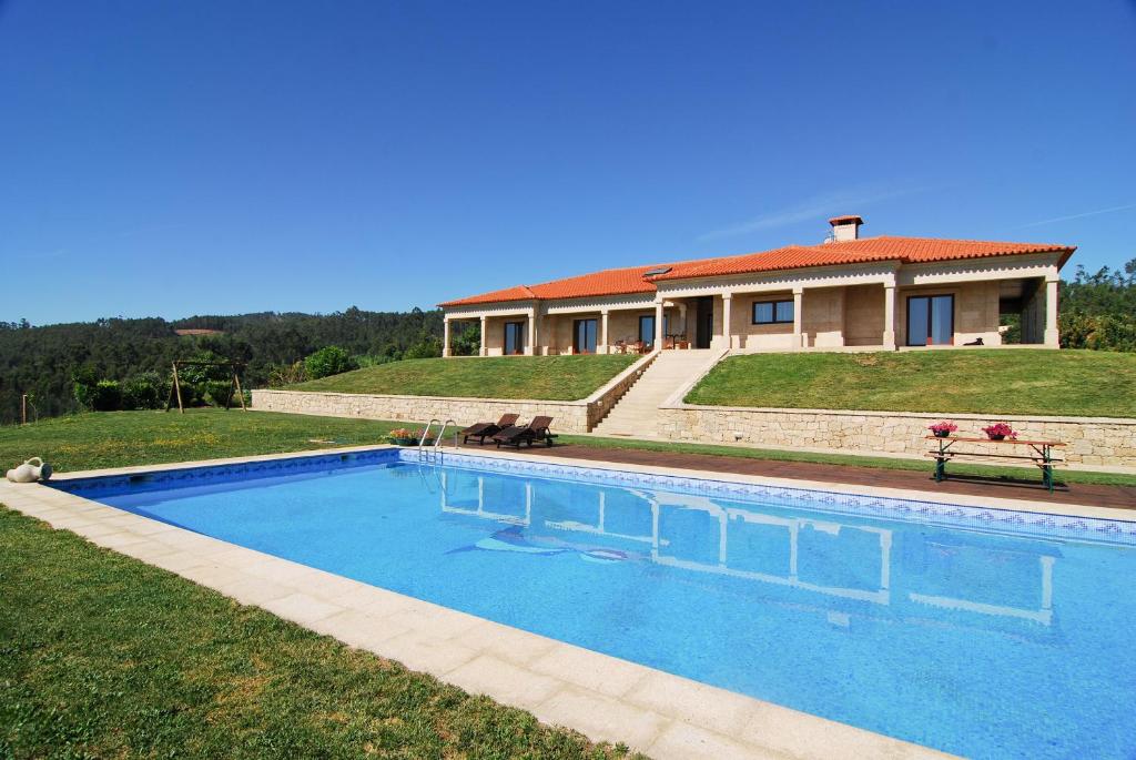a large swimming pool in front of a house at Quinta do Alto in Celorico de Basto
