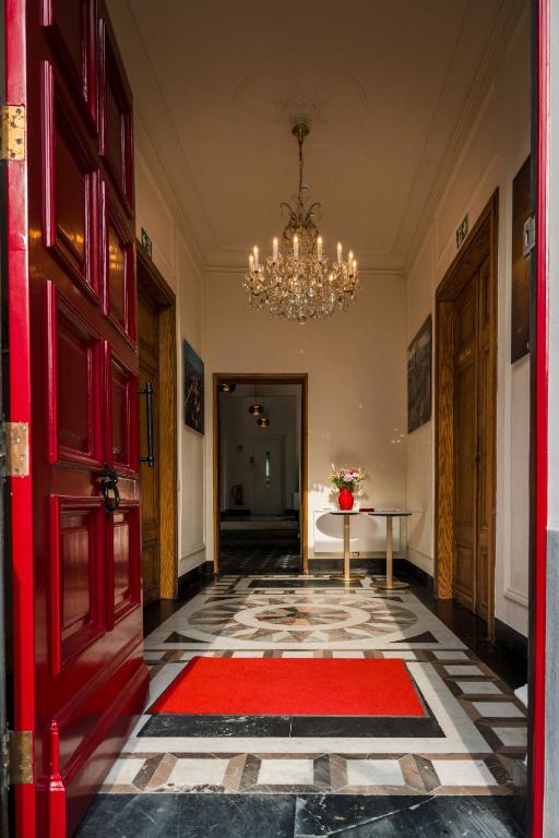a hallway with a red door and a red rug at Luxury B&B The Belgian Girl in Ghent