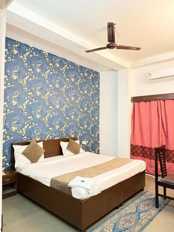 a bedroom with a bed with a blue and yellow wallpaper at Hotel Arawali Hill in Udaipur