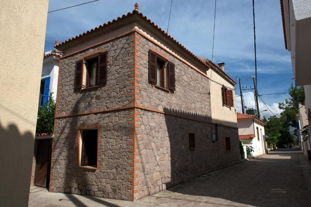 a brick building with windows on a street at Sappho House in Skala Eresou