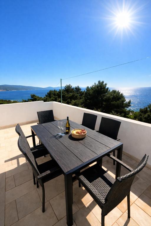 a wooden table with chairs and a bottle of wine at Apartmani Tomic in Zavalatica