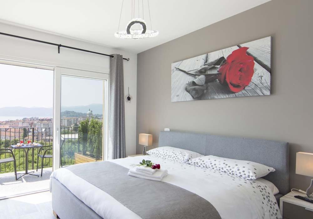 a bedroom with a large bed and a large window at Stella Maggiore in Verbania