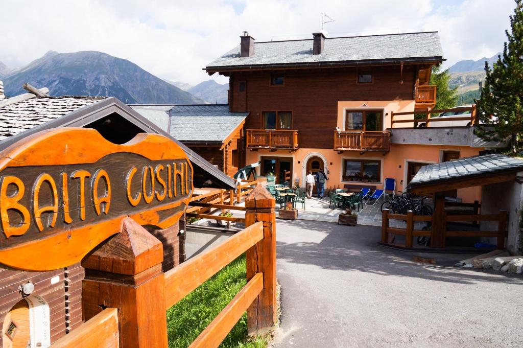 a sign for a baraja cuisine in front of a building at Residence Baita Cusini in Livigno