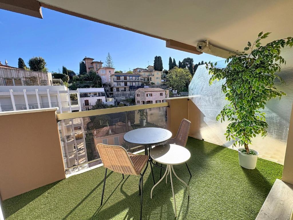 a small table and chairs on a balcony with a view at Hello Menton in Menton