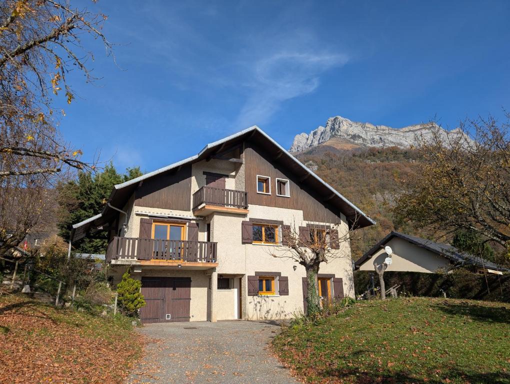 a house with a balcony and a mountain in the background at Chambres indépendantes chez l'habitant in Saint-Pierre-dʼAlbigny