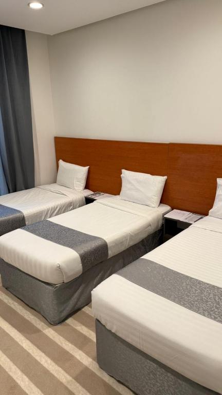 a room with three beds in a room at فندق العلاء 4 in Al Masfalah