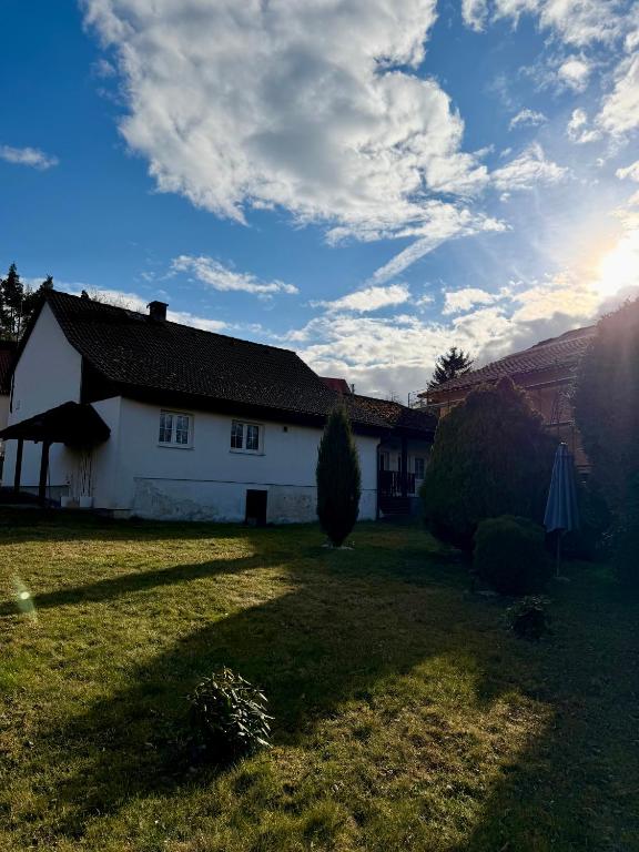 a white house in a yard with a sky at U potůčku in Ledce
