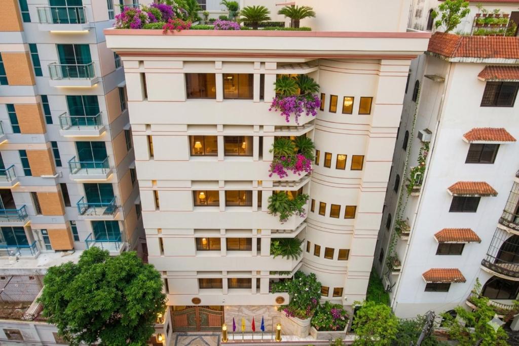 an apartment building with flowers on the balconies at Hotel Sweet Place in Dhaka