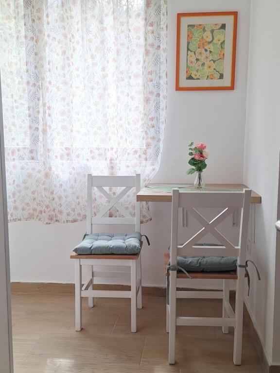 a table and two chairs next to a table and a desk with a table at Vila Dragica in Bogutovac