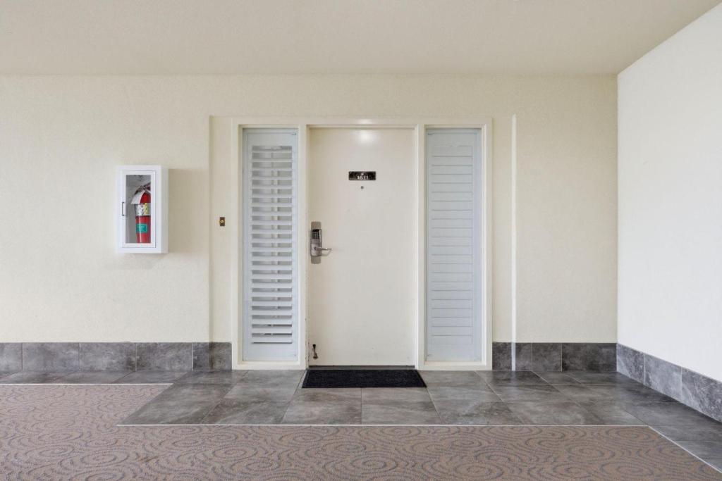 a hallway with white doors and a tile floor at The Oasis at Orange Beach 1611 (Phoenix West II) in Orange Beach