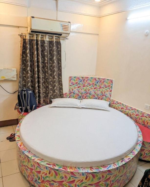 a room with a large bed and a chair at hotel bhagwati patel bright in Indore