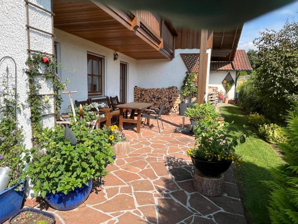 a patio with a table and some potted plants at Ferienwohnung Sonnenblick in Grafenwiesen