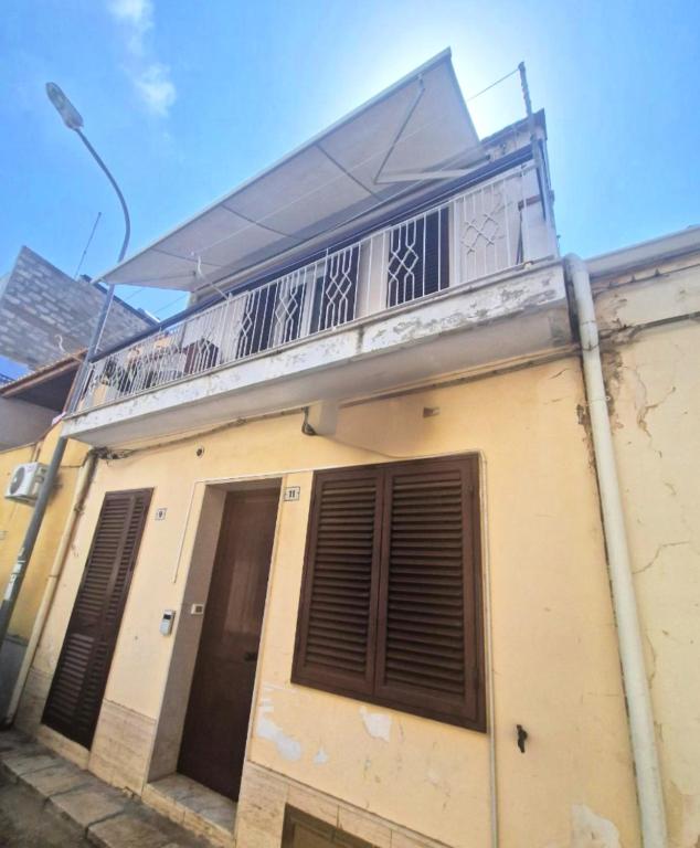 a building with a balcony on top of it at House 100 meters from the beach in Marina di Ragusa