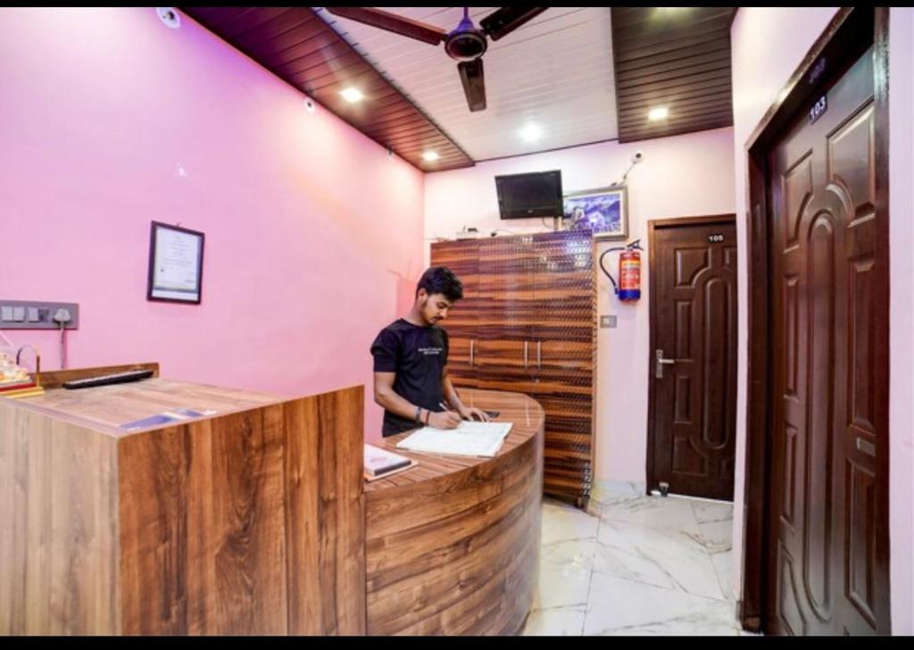 a man standing at a bar in a room at Guest inn bharat mart in Haldwāni