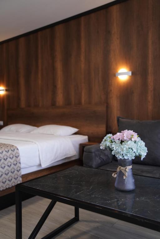 a hotel room with a bed and a table with flowers at Aventus Hotel in Akhaltsikhe