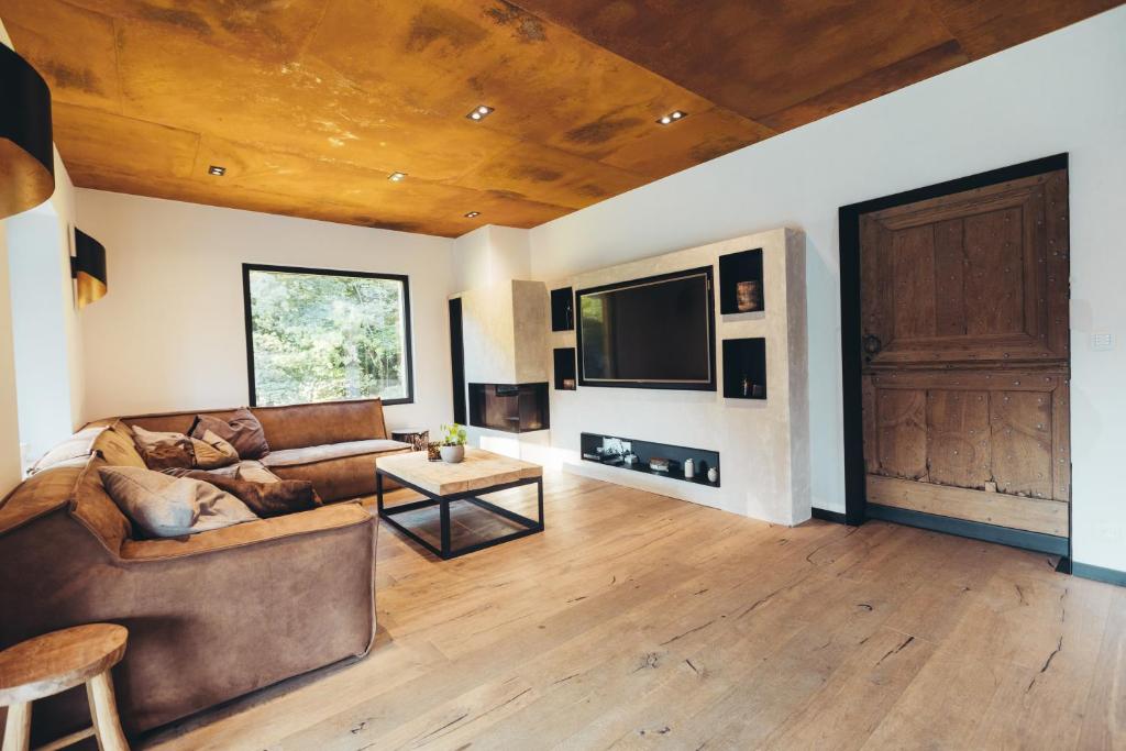 a living room with a couch and a flat screen tv at La fagnette in Jalhay