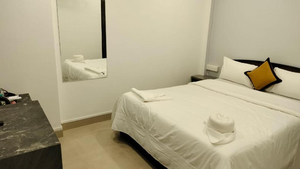 a white bed in a room with a mirror at RKS Homestay Anex in Shillong