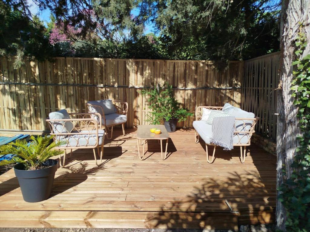 a patio with chairs and a table and a fence at La maison Françine in Sénas
