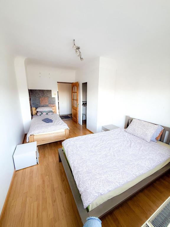 a bedroom with two beds and wooden floors at Mājīgs dzīvoklis Aizputē in Aizpute