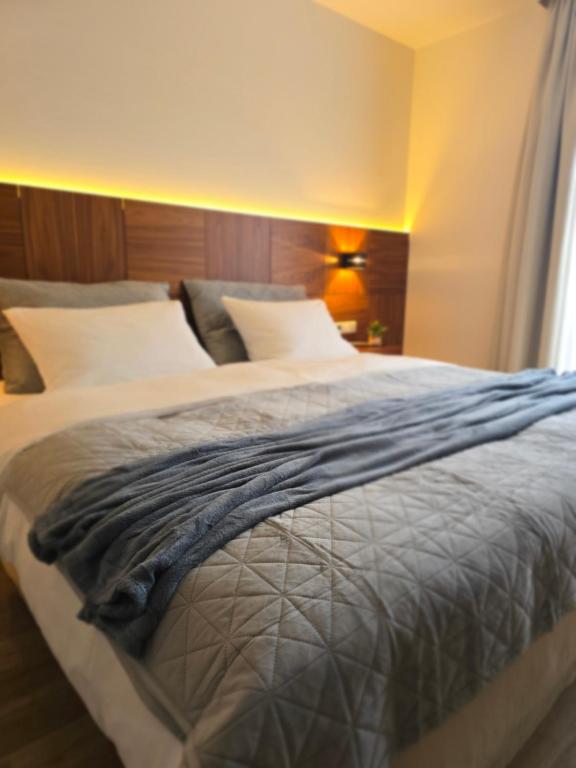 ein Schlafzimmer mit einem großen Bett mit weißen Laken und Kissen in der Unterkunft LoC Kannenkeller Smart Stay in Lauingen